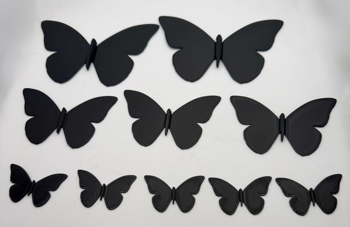 Three sizes of 3D printed butterfly wall decorations laid flat