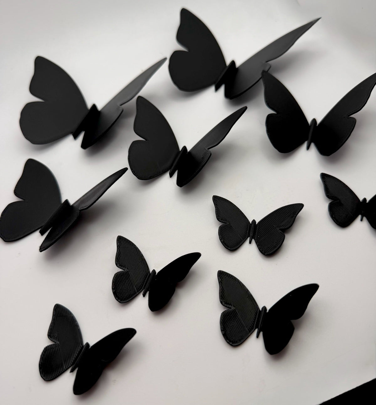 Black butterfly wall decorations with raised wings casting shadows