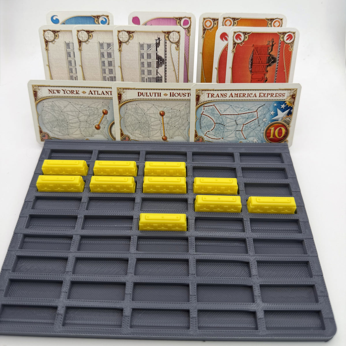 Grey player tray with individual train slots, yellow train pieces seated in the slots and cards standing in the rear channels - compatible with Ticket to Ride