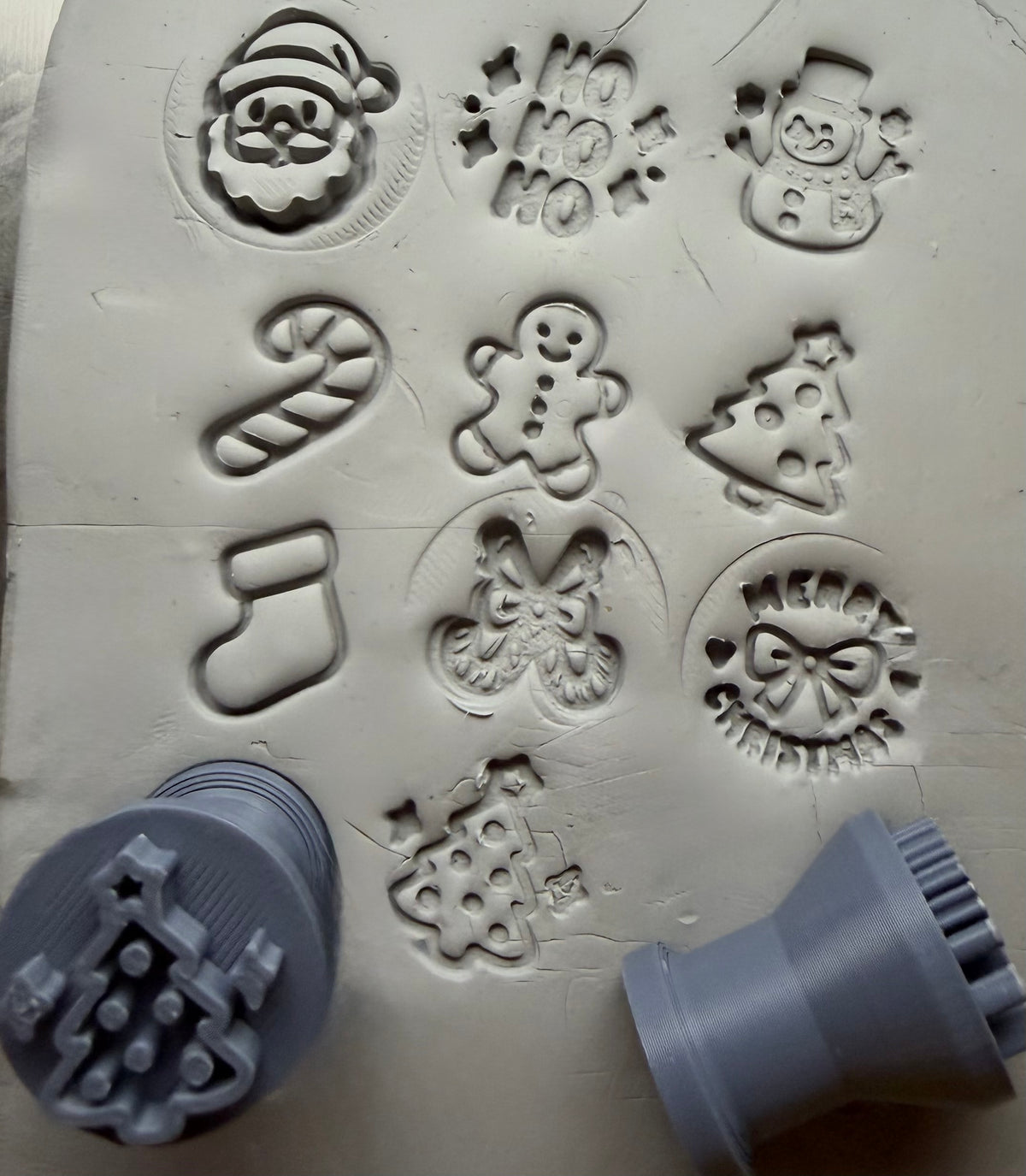 Christmas stamp impressions in grey clay with two of the stamps