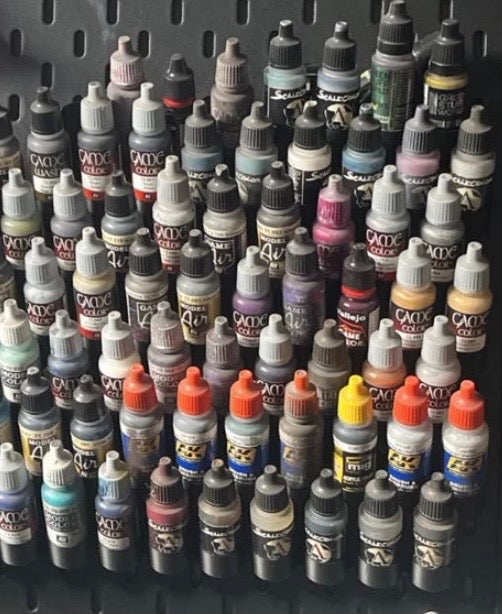 Close-up of dropper bottle paint holders on a customer SKÅDIS wall