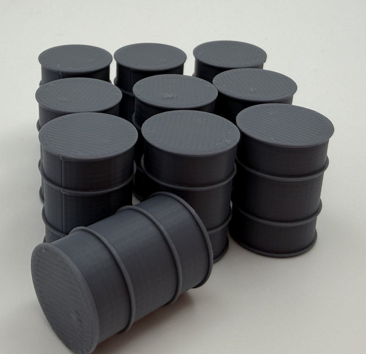 Stack of 3D printed industrial fuel drums with one drum on its side