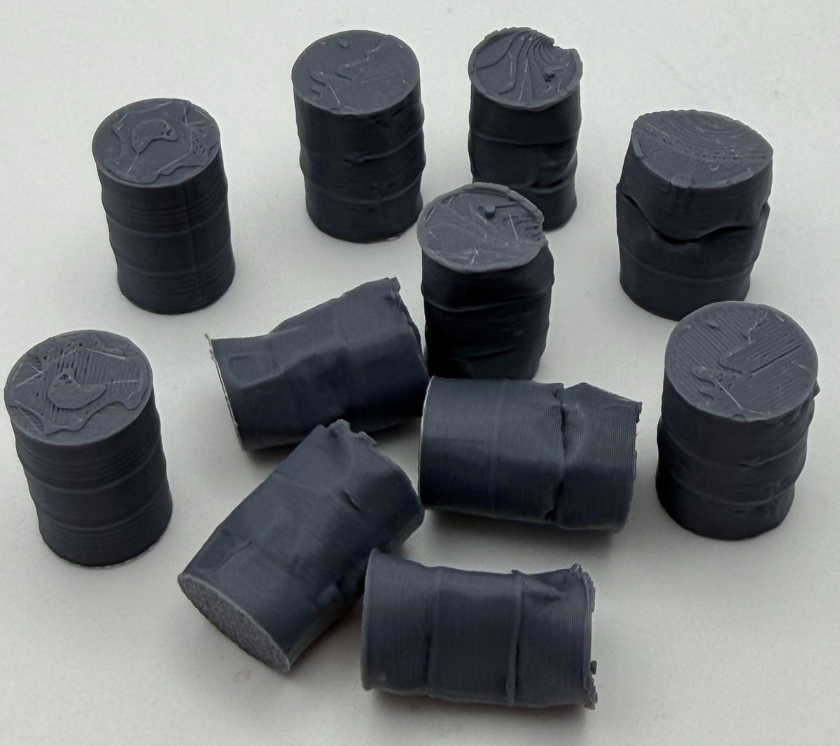 Mixed oil drums spread out showing dented and crushed designs