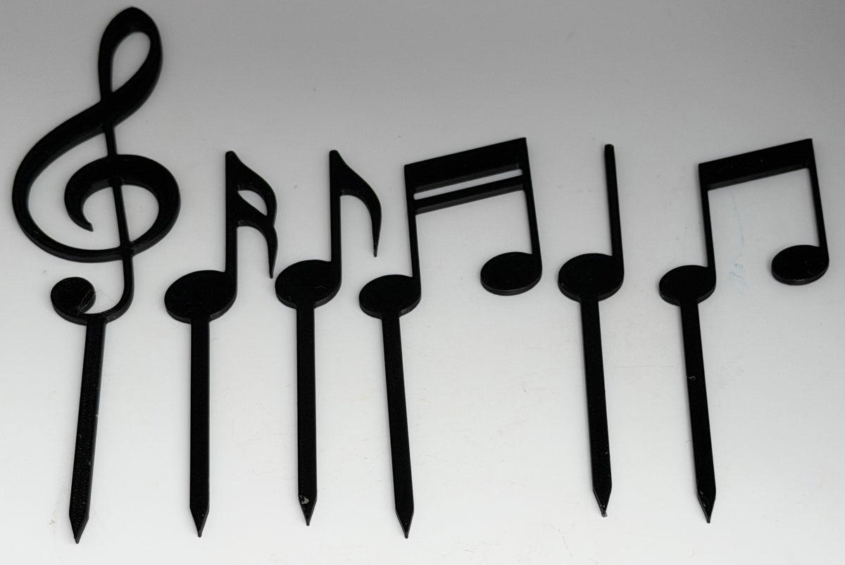 6 piece black music notes cake topper set laid flat