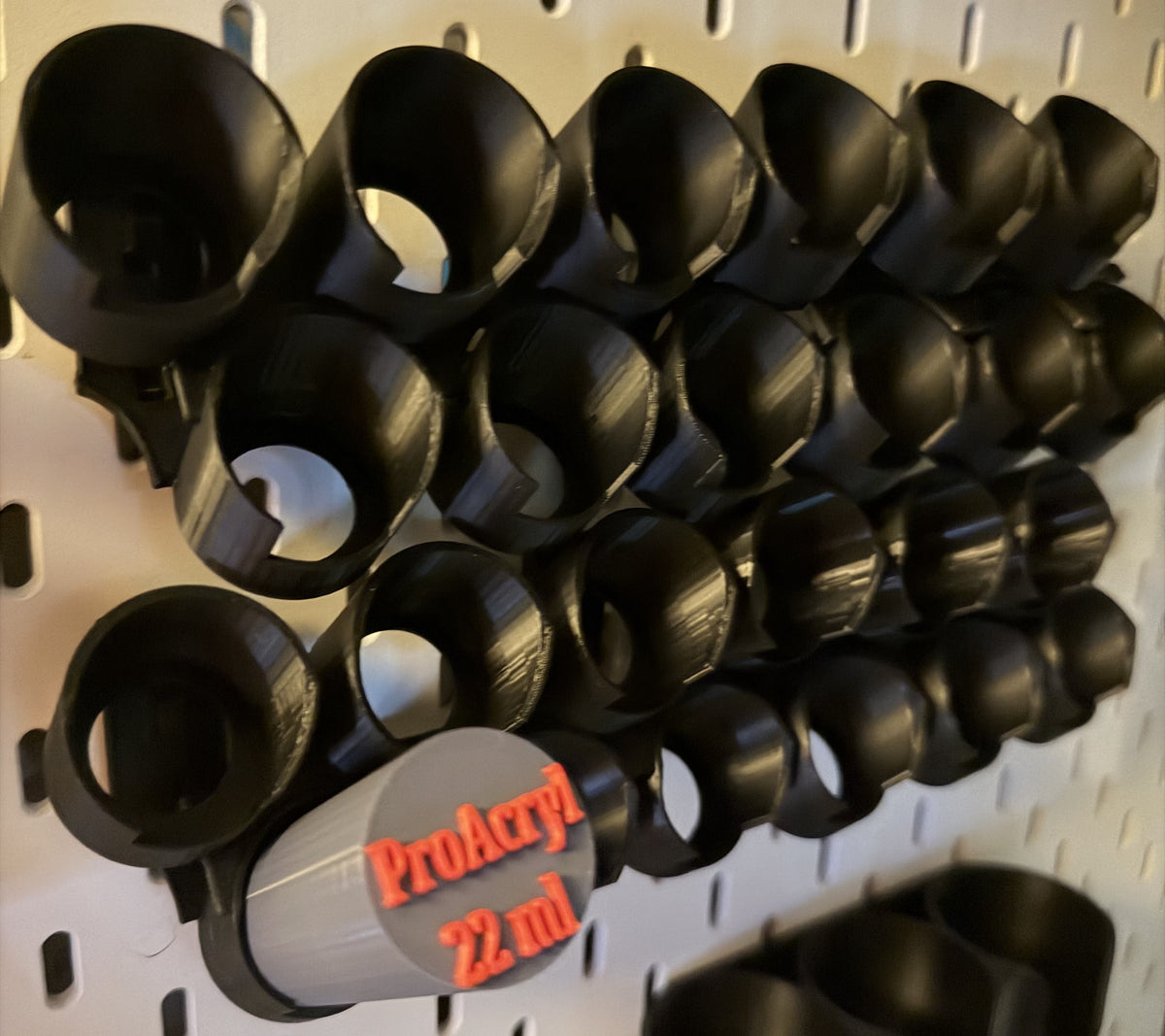 Black Pro Acryl 22 ml paint holders on a white IKEA SKÅDIS pegboard - angled view