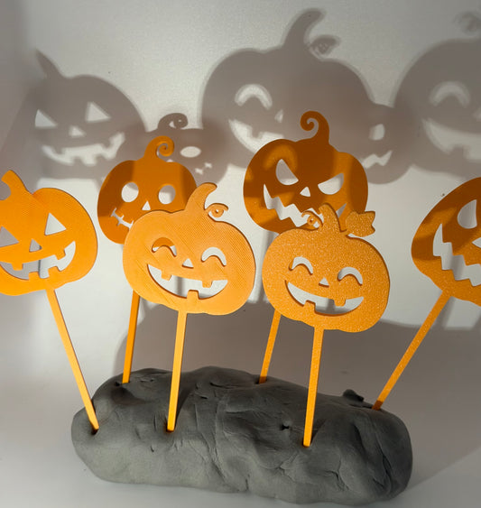 Six orange jack-o'-lantern cake toppers with different faces
