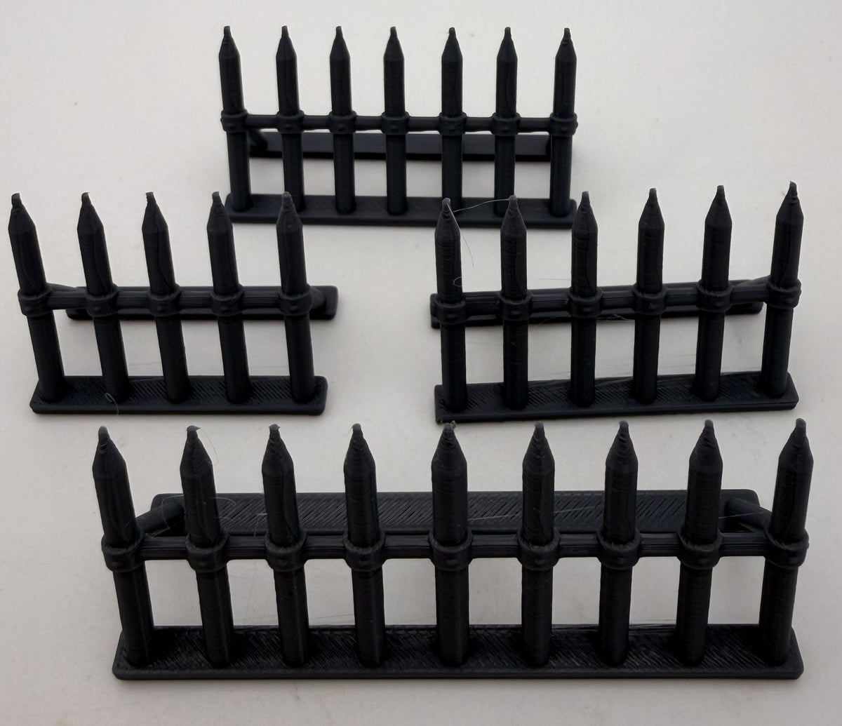 Four spiked barricades of different lengths arranged as a defensive line